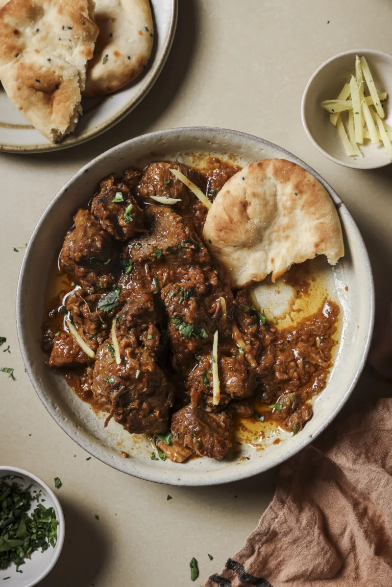 Pakistanisches Lamm Curry mit Ingwerstreifen, serviert mit Naan-Brot