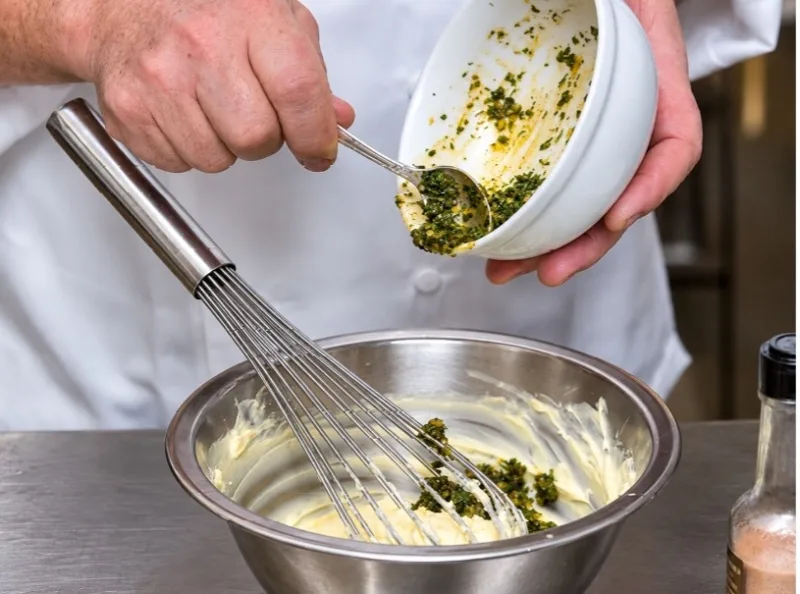 Kräuterbutter für Café-de-Paris-Kruste wird in einer Schüssel verrührt